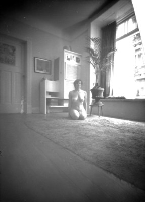 Mujer desnuda junto a ventana